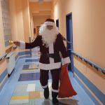 Święty Mikołaj idzie korytarzem i dzwoni dzwonkiem.