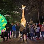 Wspólne zdjęcie uczestników wycieczki. W tle świetlna żyrafa.