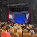 Sala Wrocławskiego Teatru Lalek. Widzowie siedzą na krzesłach. Odwróceni są w stronę sceny i kurtyny.