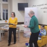Pani Aneta i Pani Agnieszka wręczają podziękowanie Dawidowi za udział w warsztatach dziennikarskich. Obok siedzi Alicja i klaszcze pani Magda.