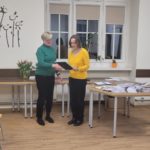 Pani Aneta odczytuje treść dyplomu dla uczestnika warsztatów dziennikarskich. Obok stoi Pani Agnieszka.
